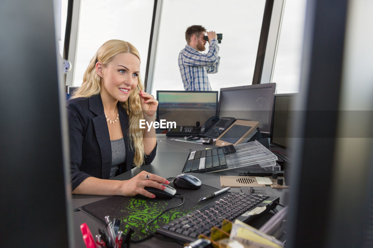 Cheerful female dispatcher working in office