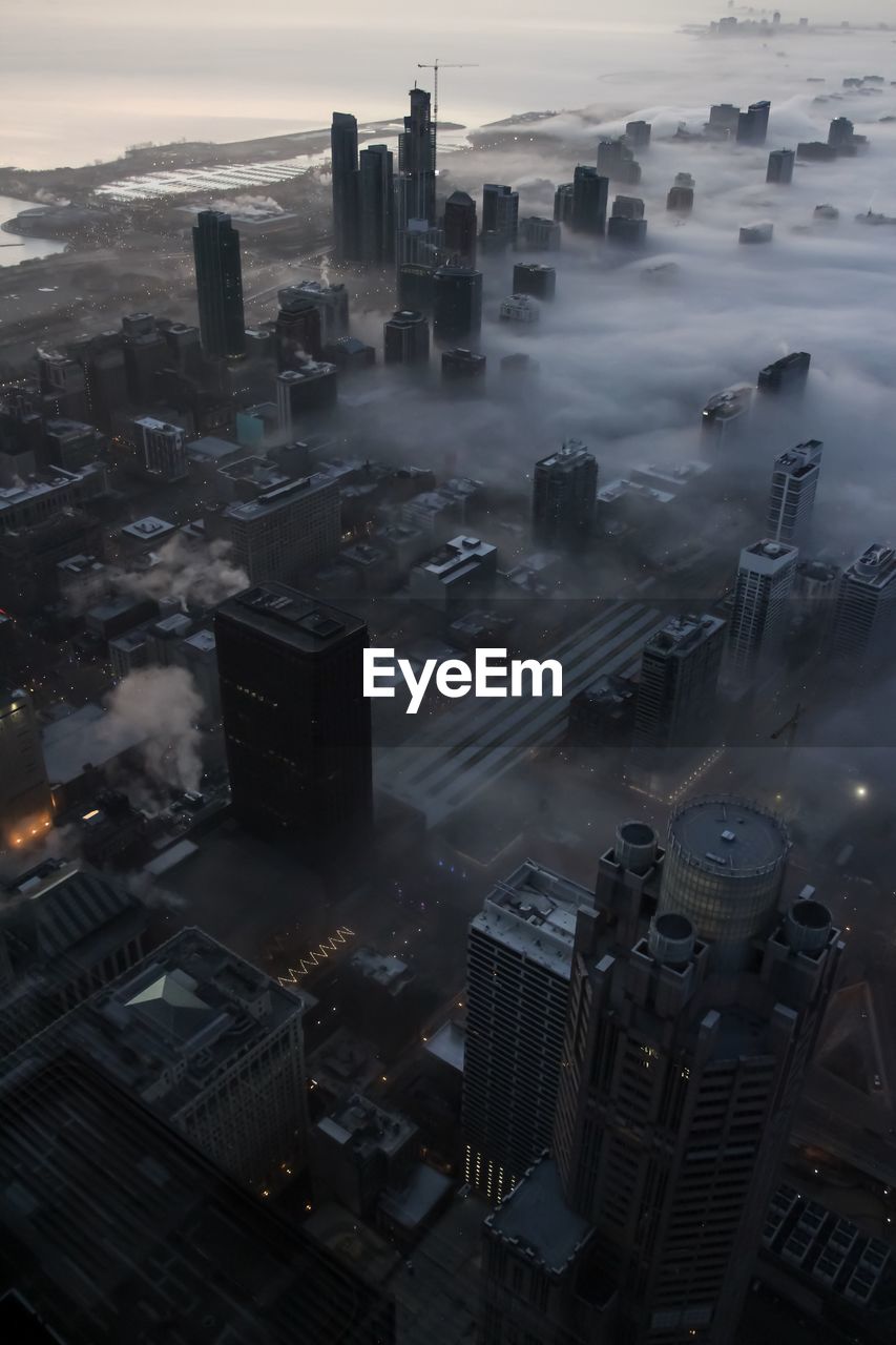 HIGH ANGLE VIEW OF MODERN BUILDINGS IN CITY AGAINST SKY