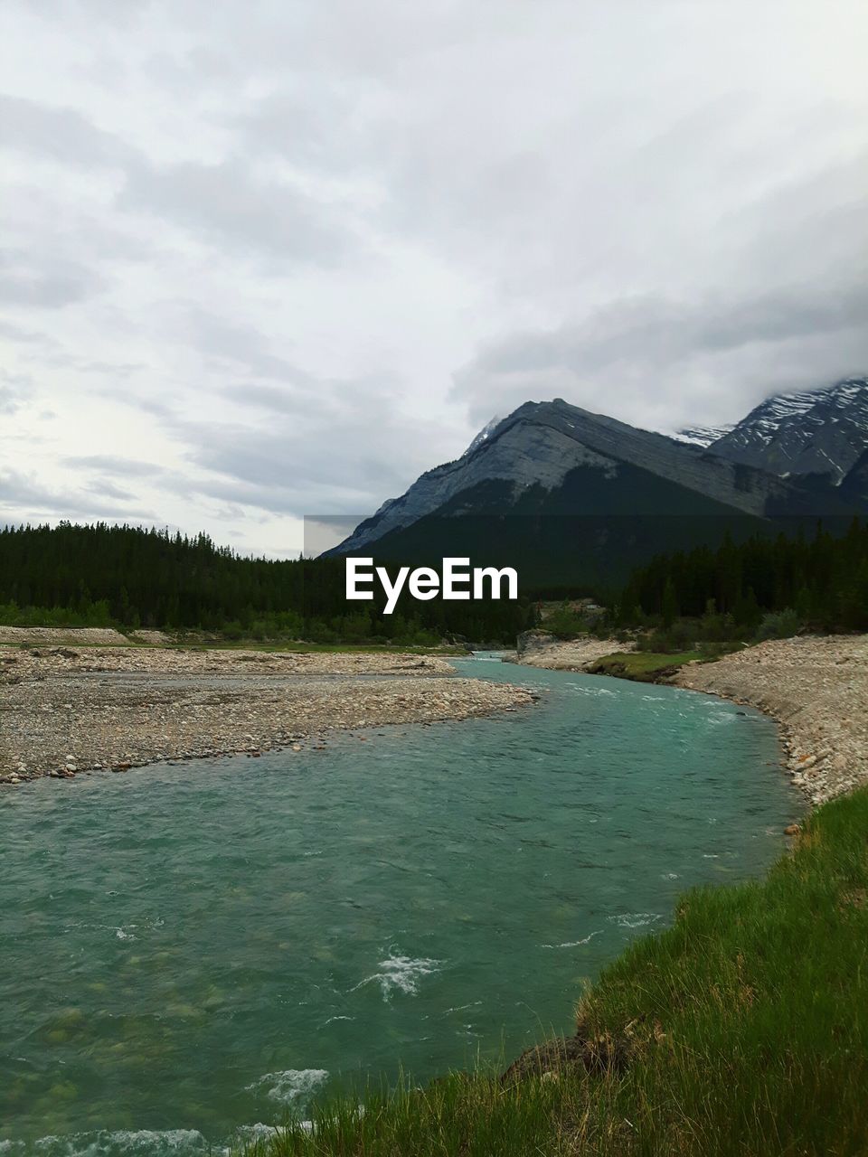 VIEW OF CALM COUNTRYSIDE LAKE AGAINST MOUNTAIN