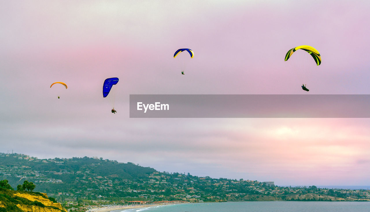 Several paragliders flying in the sunset sky over la jolla, california