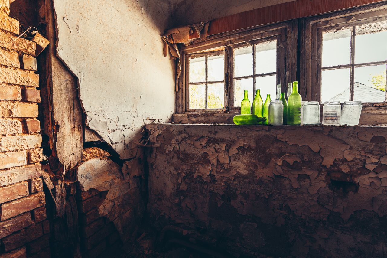 View of weathered wall with some green bottles 