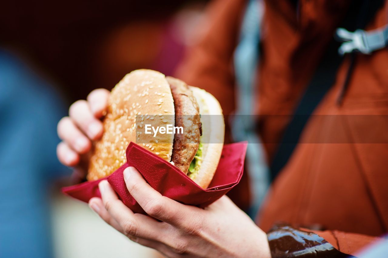 Cropped hands holding burger