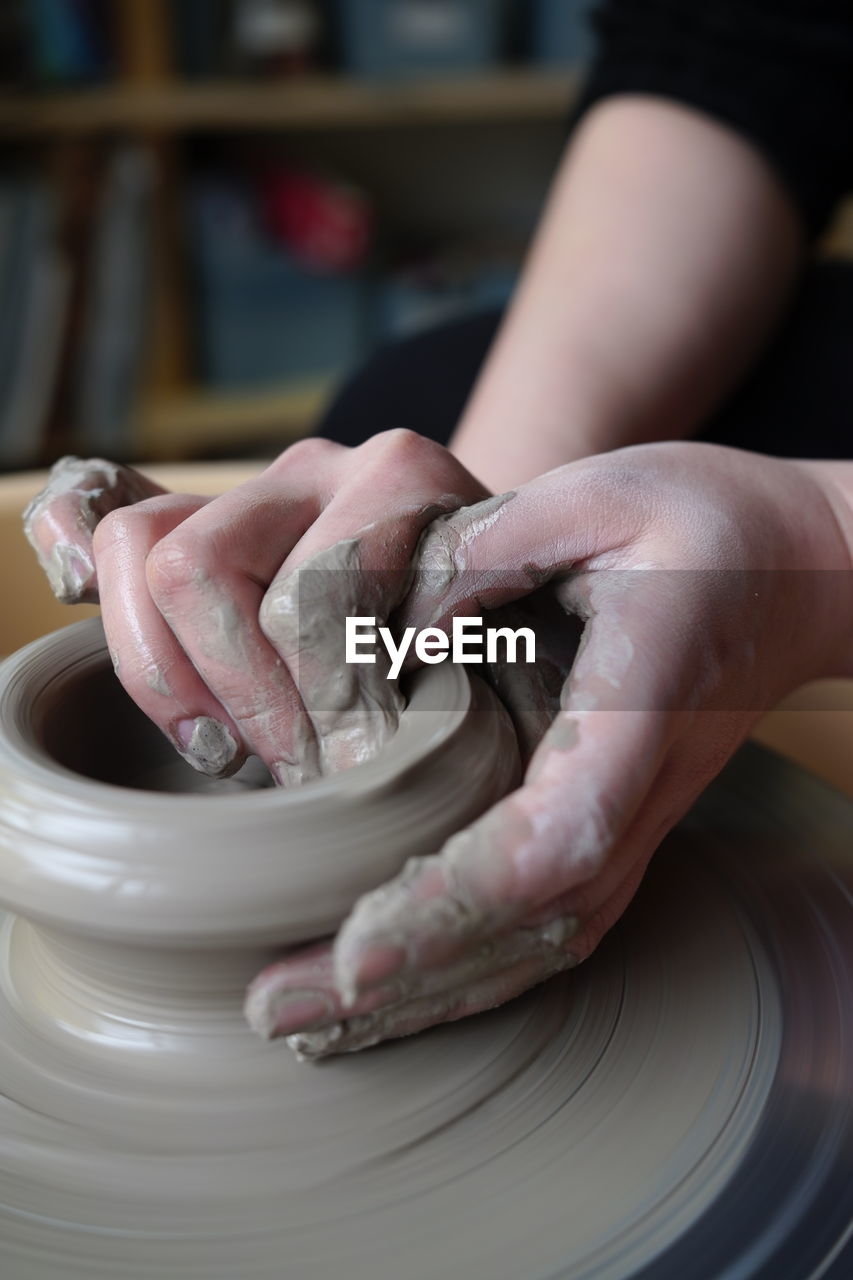 Cropped hands of woman making pottery