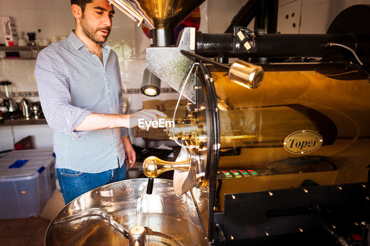 Barista preparing coffee in machinery at cafe