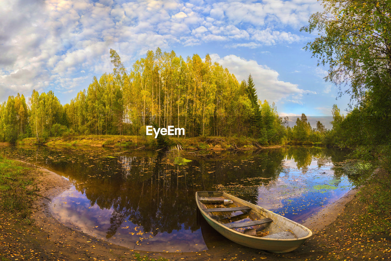 BOAT MOORED BY LAKE AGAINST SKY