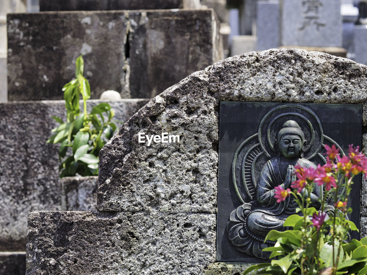 Buddha carving on stone wall at cemetery