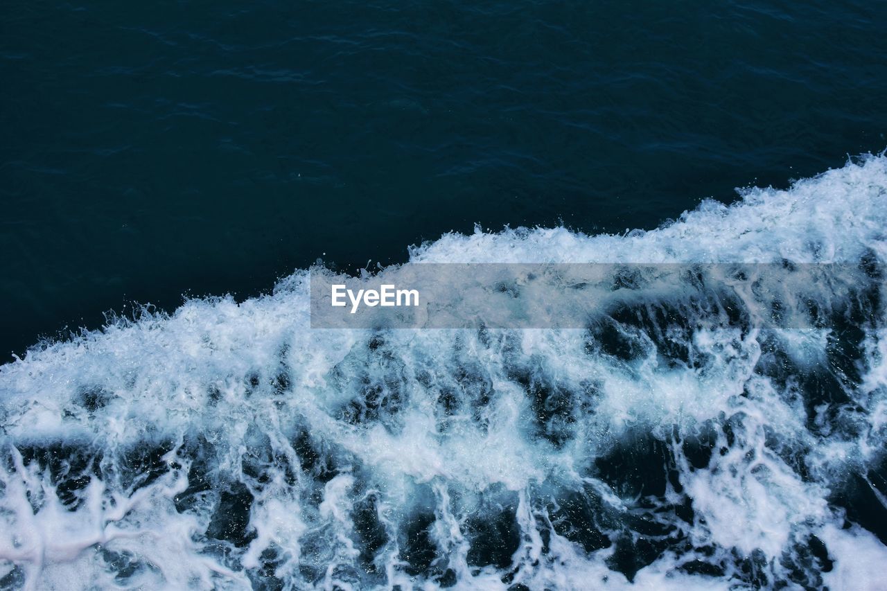 HIGH ANGLE VIEW OF WAVE ON SEA