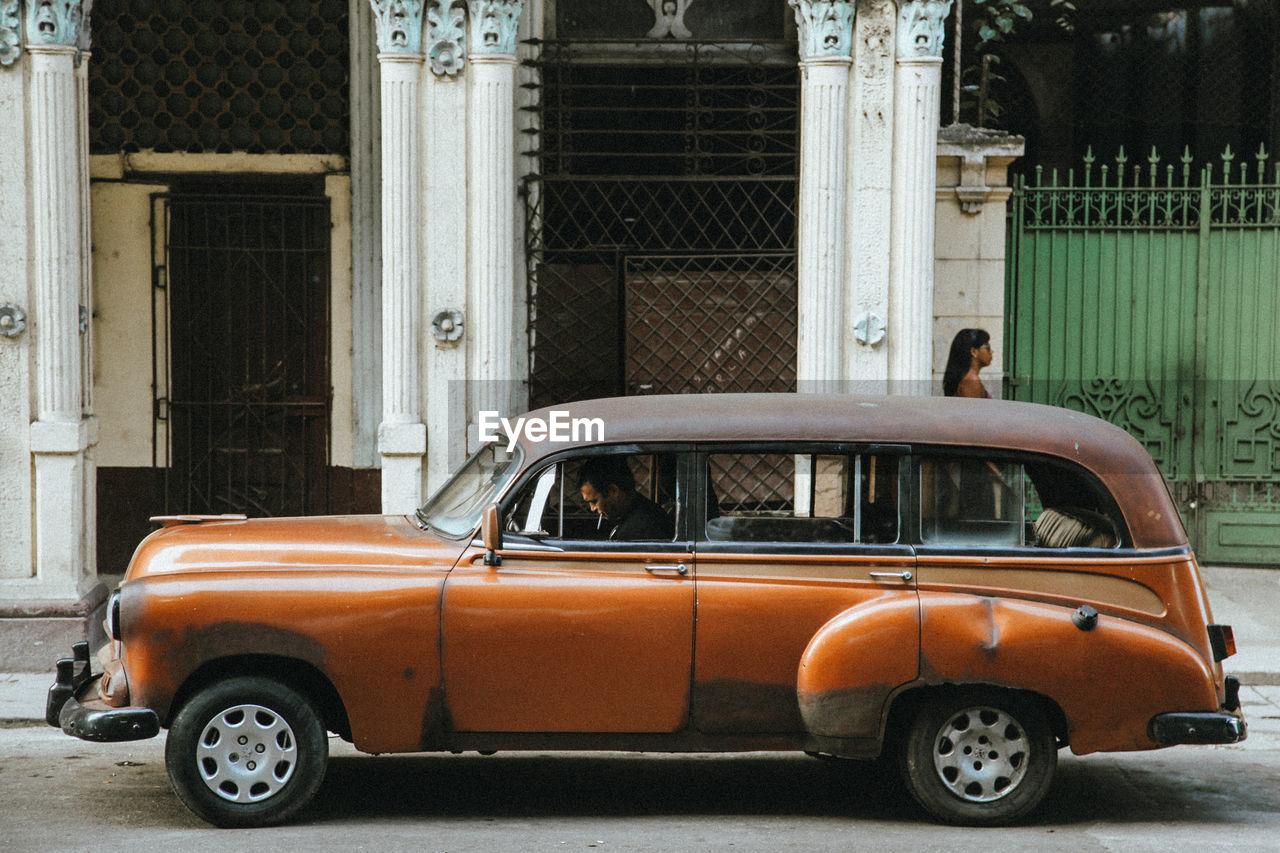 VINTAGE CAR ON STREET AGAINST BUILDING