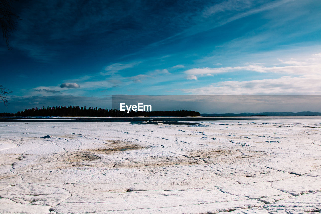 Scenic view of beach against blue sky