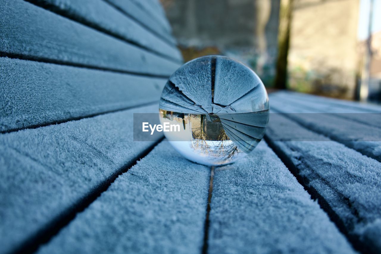 blue, close-up, white, reflection, no people, light, black, day, outdoors, nature, selective focus, macro photography, glass, city, sphere, winter, architecture, sunlight, street, single object, focus on foreground, wood