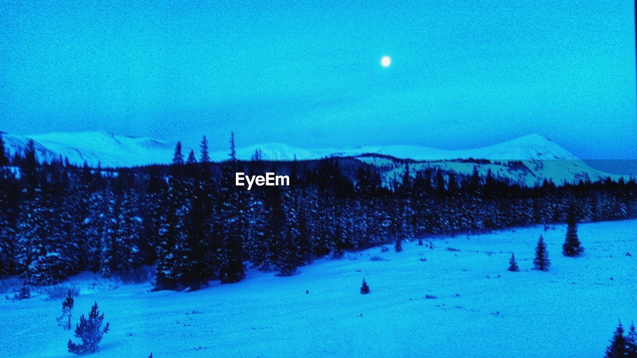 PANORAMIC VIEW OF SNOWCAPPED LANDSCAPE AGAINST BLUE SKY