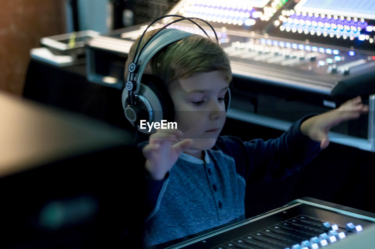 Close-up of boy using sound mixer in studio