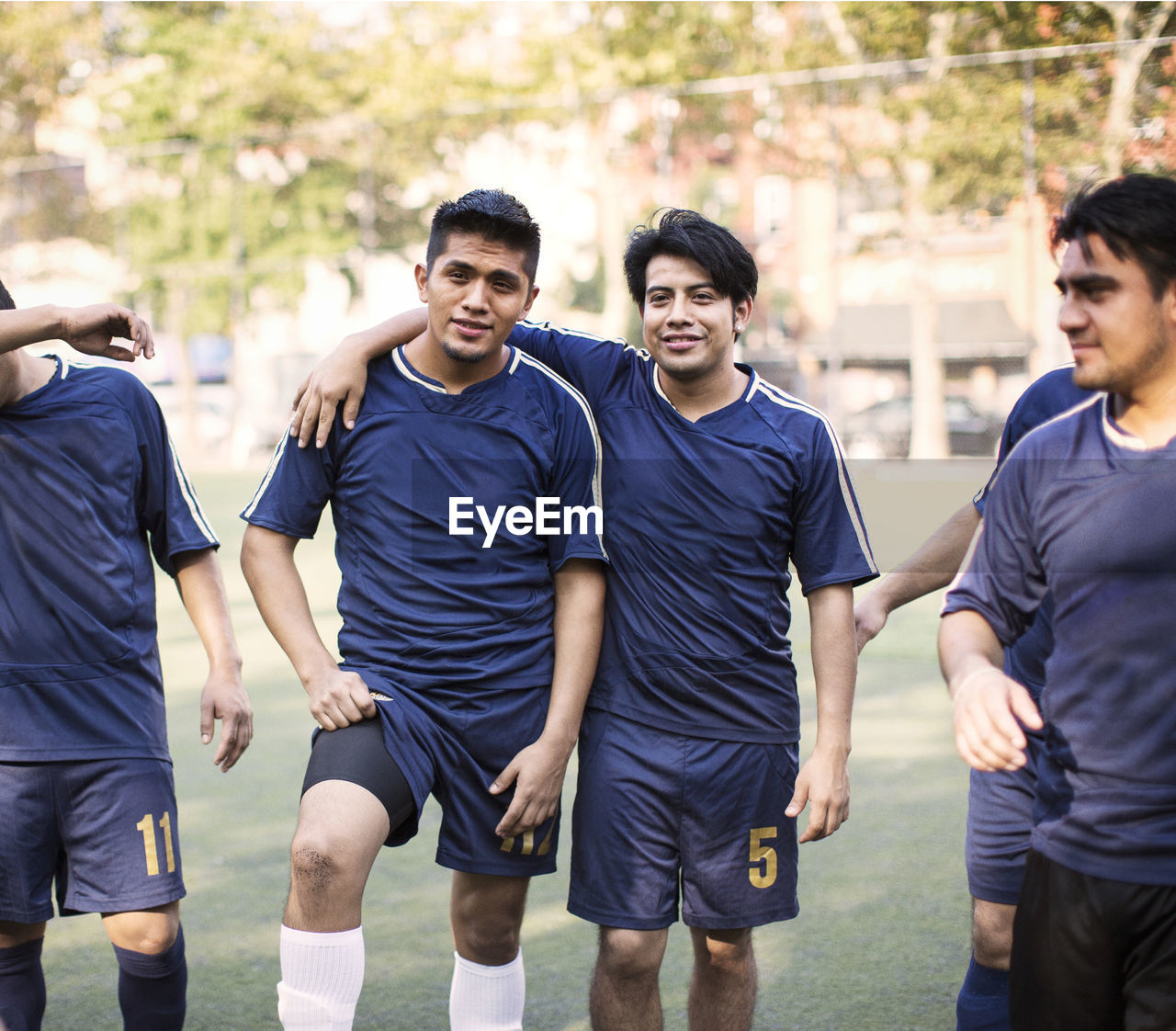 Happy soccer team standing at field