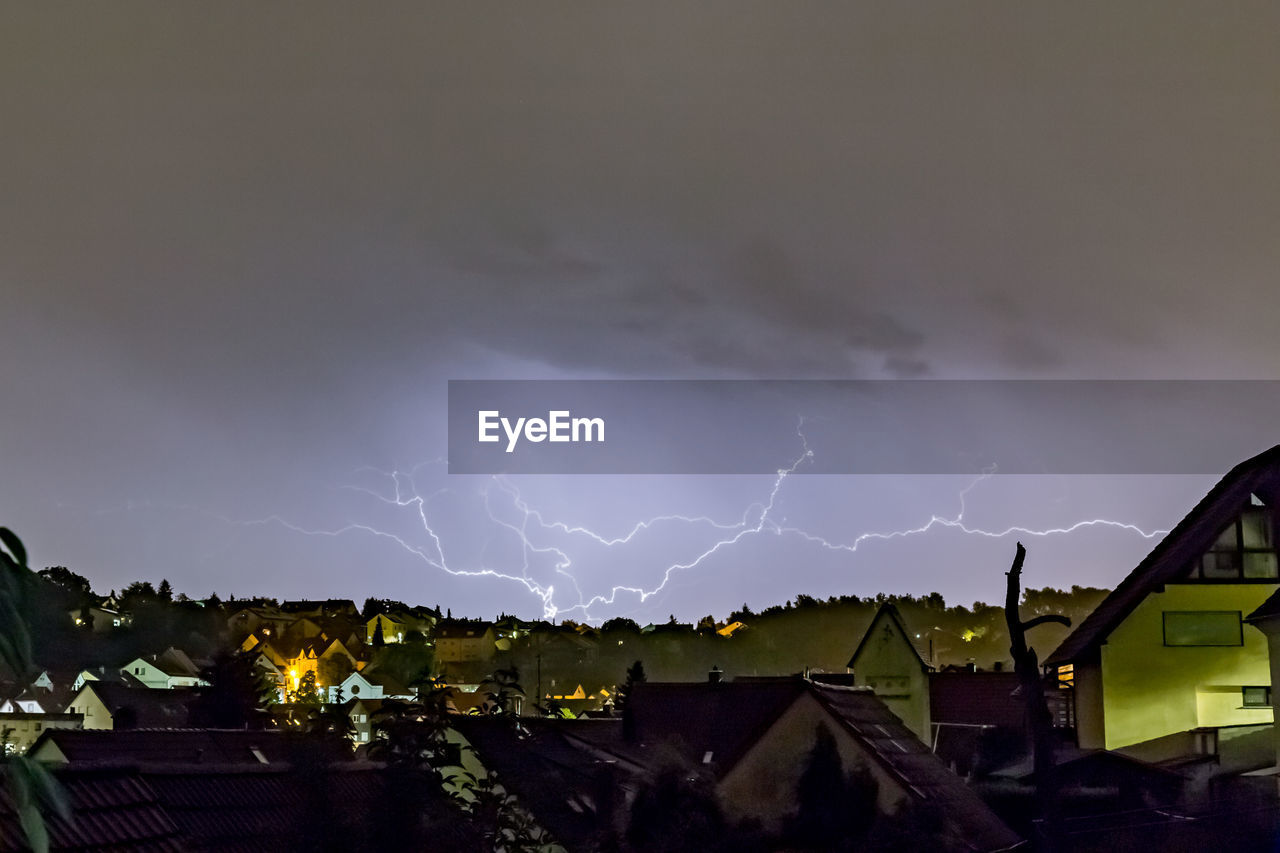 PANORAMIC VIEW OF LIGHTNING OVER BUILDINGS AGAINST SKY