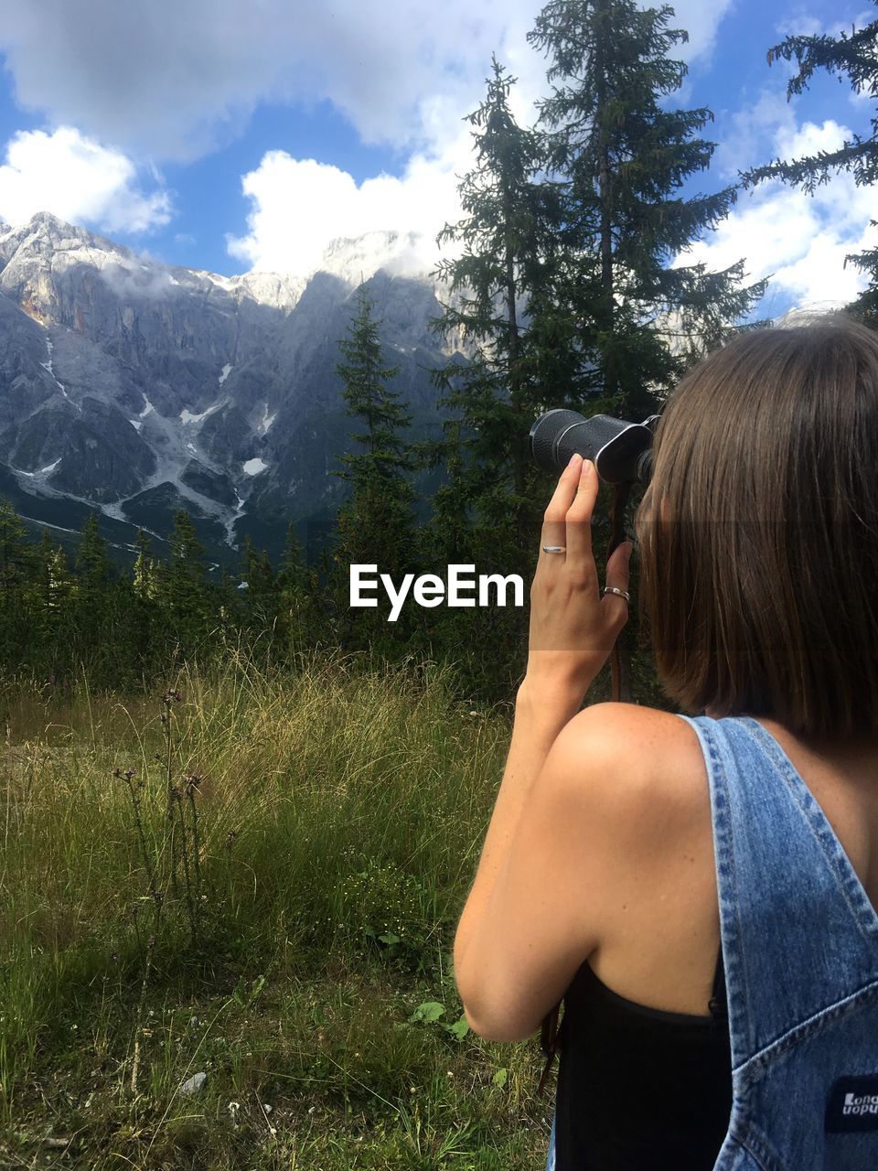 REAR VIEW OF WOMAN AGAINST MOUNTAIN RANGE AND SKY