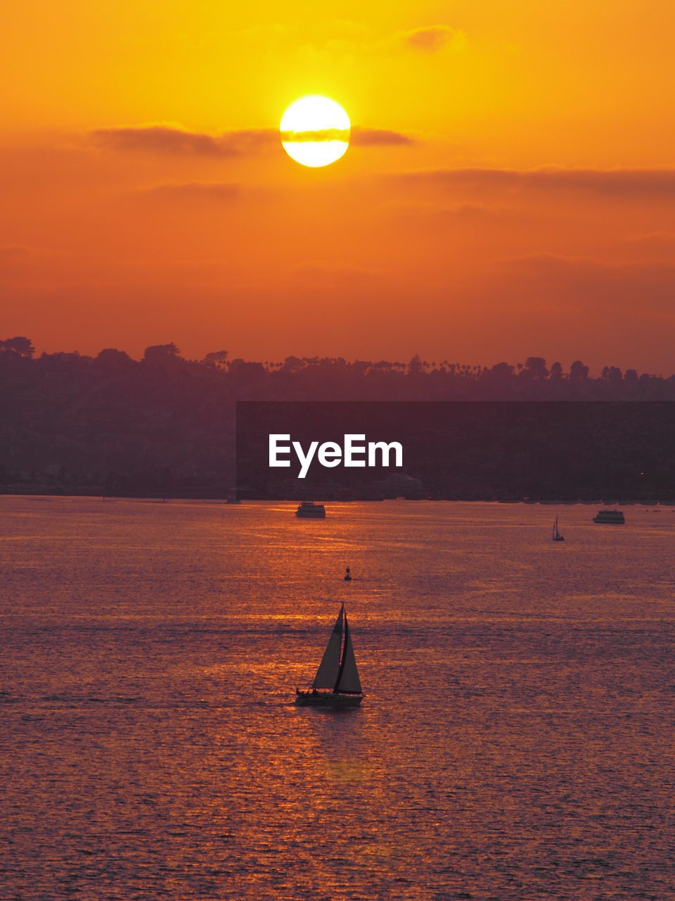 Silhouette sailboat sailing on sea against sky during sunset