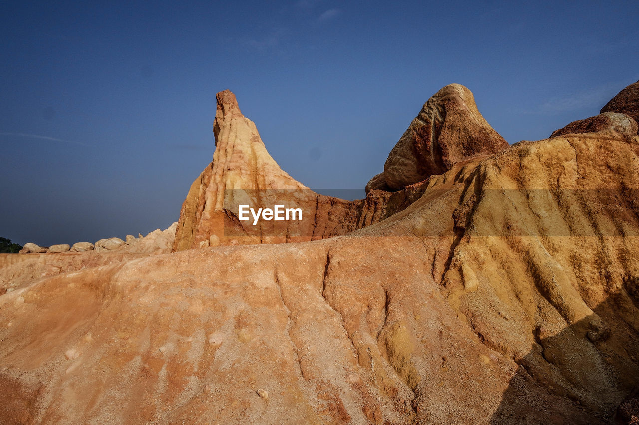 Low angle view of rock formations against sky