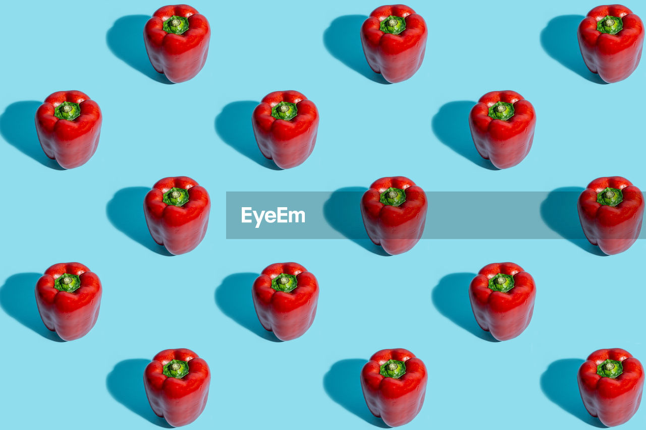 Pattern made of red bell pepper on pastel blue background