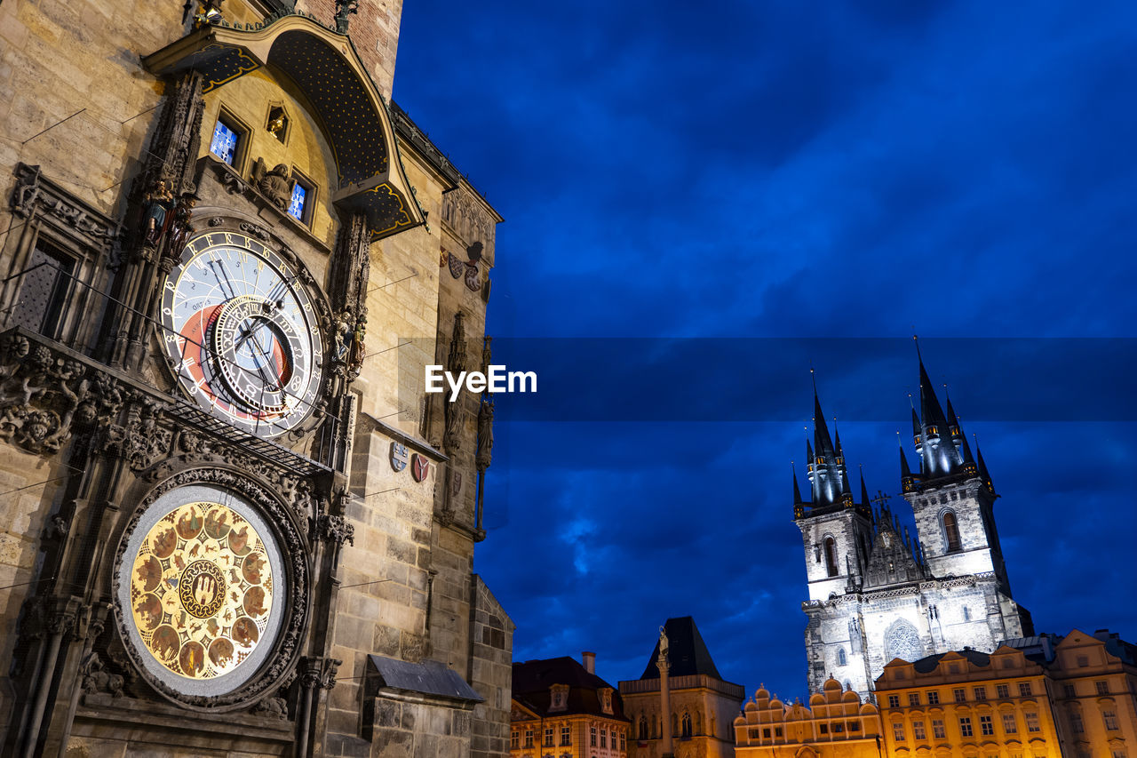 architecture, clock, building exterior, built structure, tower, clock tower, time, travel destinations, building, landmark, sky, city, worship, history, the past, travel, night, low angle view, clock face, place of worship, tourism, gothic style, religion, nature, roman numeral, spire, blue, no people, cloud, astronomical clock, wall clock, belief, spirituality, bell tower, space, dusk, outdoors, cityscape, old, illuminated, town, astronomy