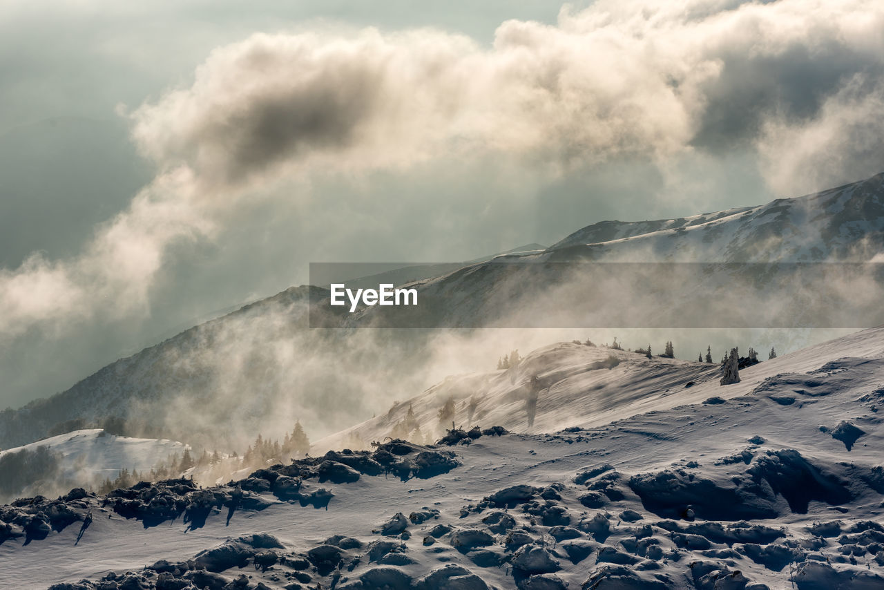 Scenic view of snow covered mountains against sky