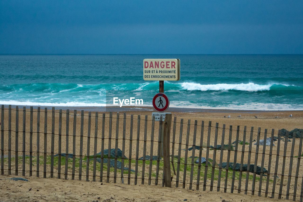 Danger sign on fence at beach