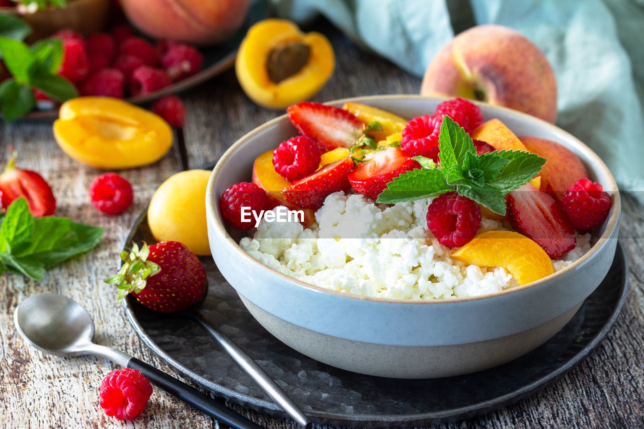 Rustic summer breakfast or dessert. curd or cottage cheese served with fresh summer fruits. 