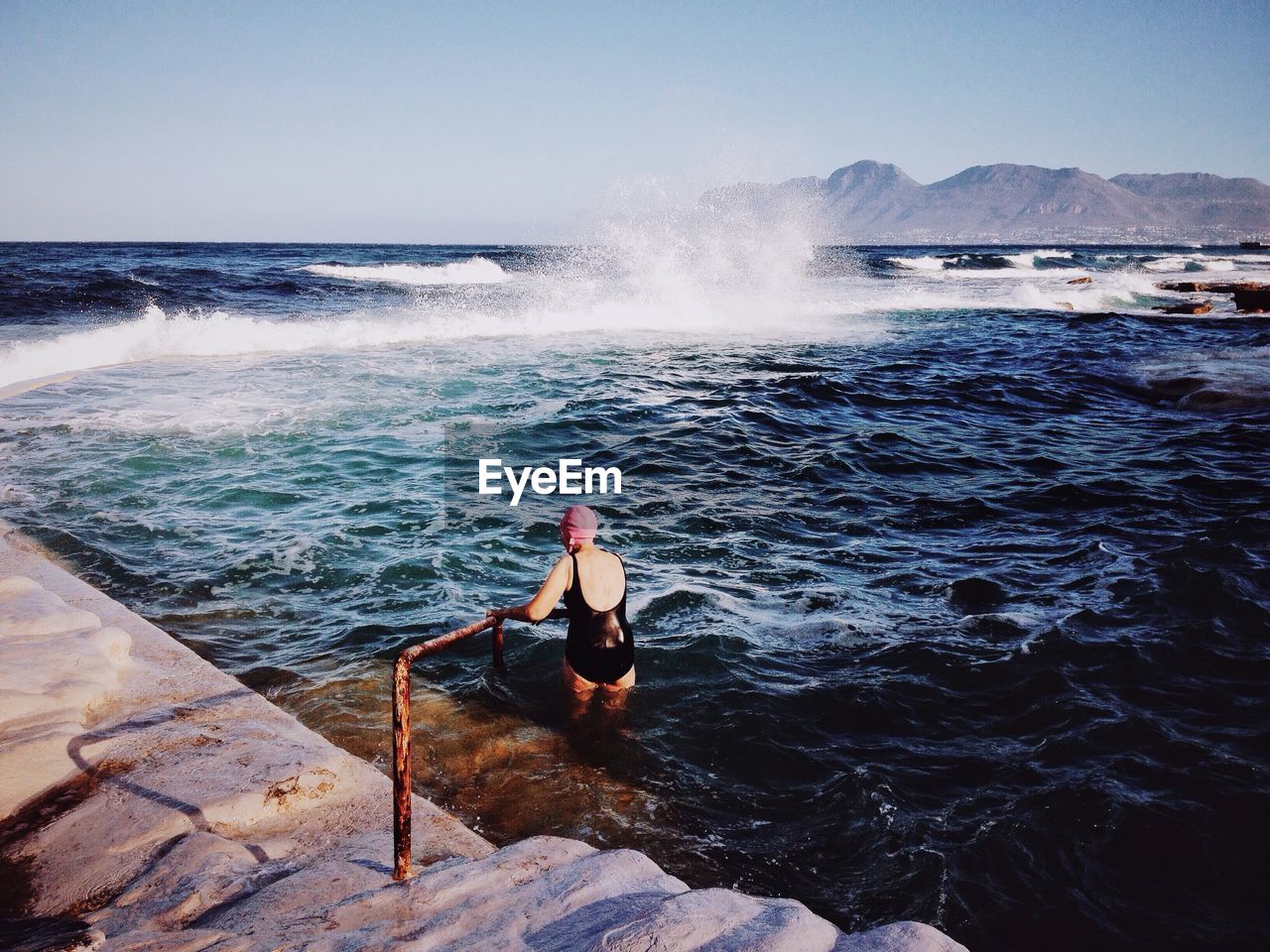 Woman in sea against sky