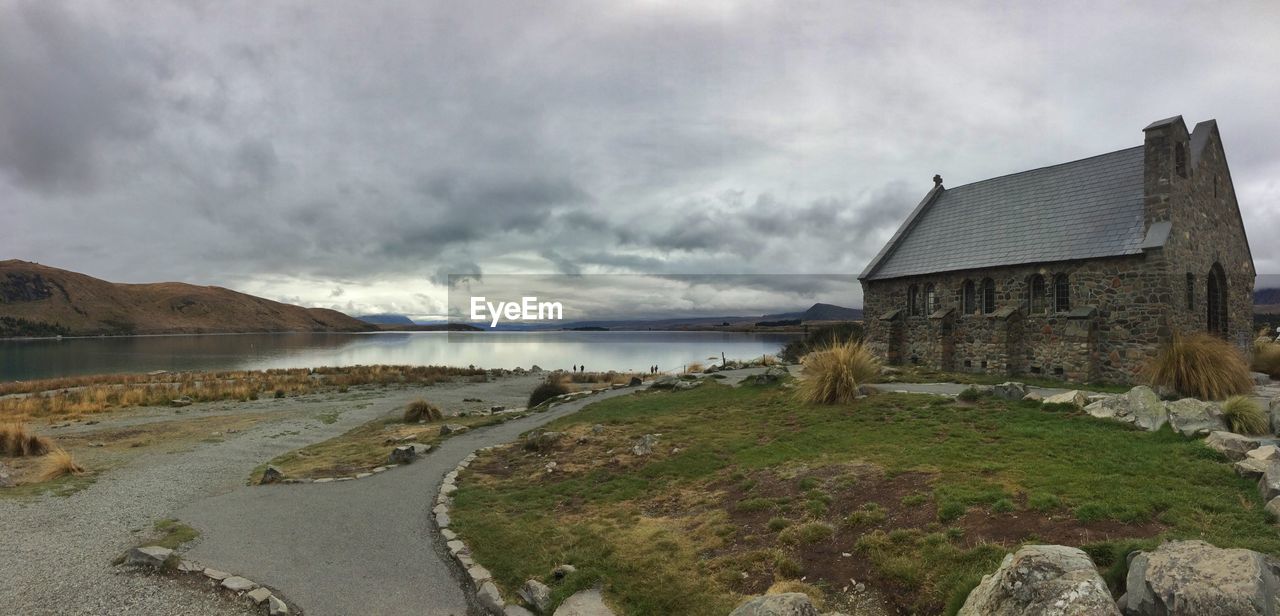 SCENIC VIEW OF HOUSES BY BUILDINGS AGAINST SKY