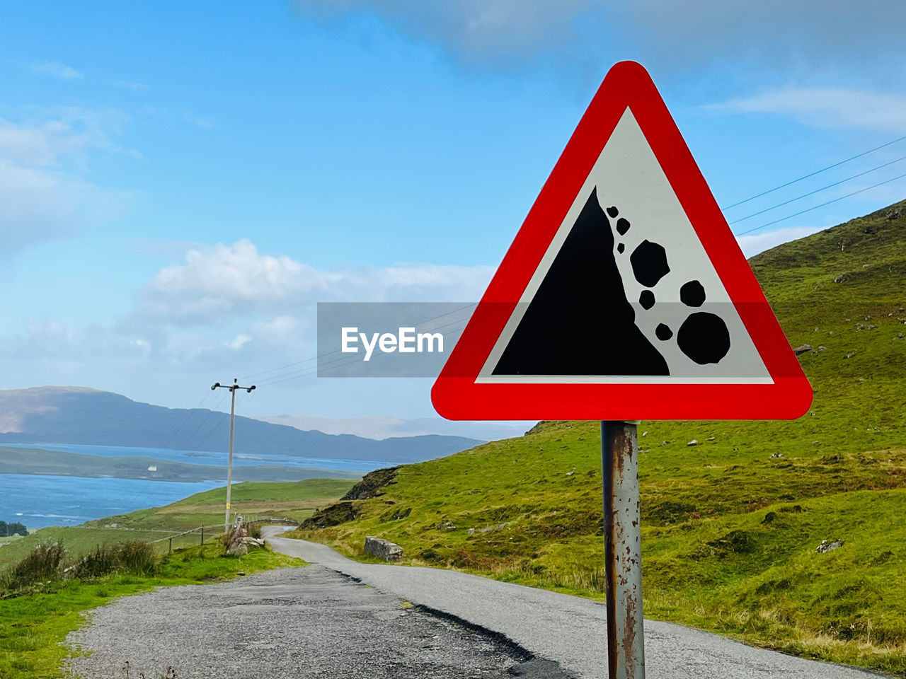 Close-up of road sign against sky