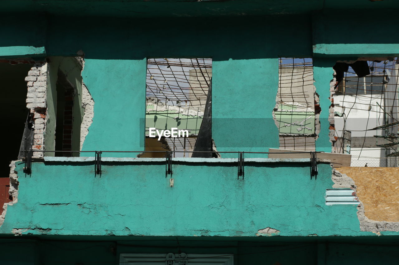 LOW ANGLE VIEW OF BLUE WINDOW ON OLD BUILDING