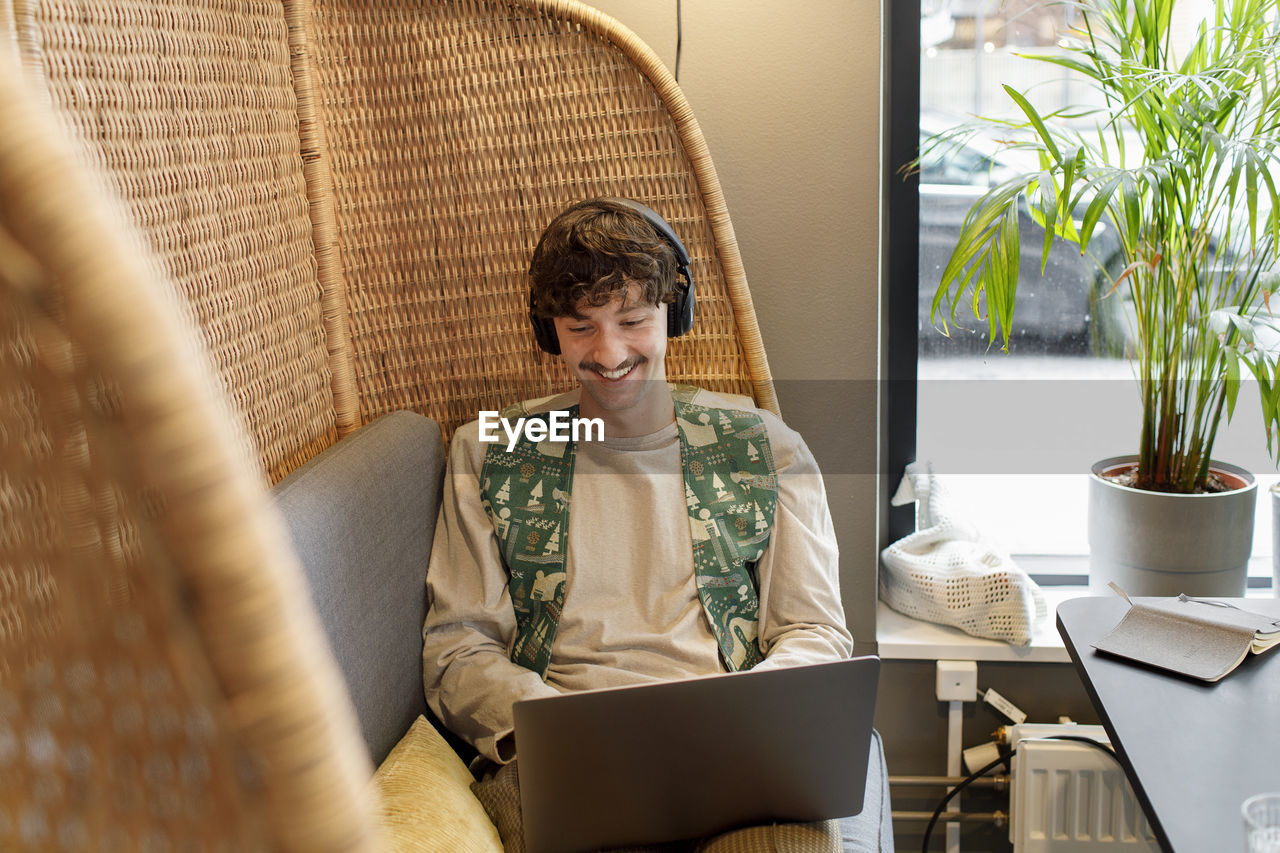 Young man using laptop in cafe