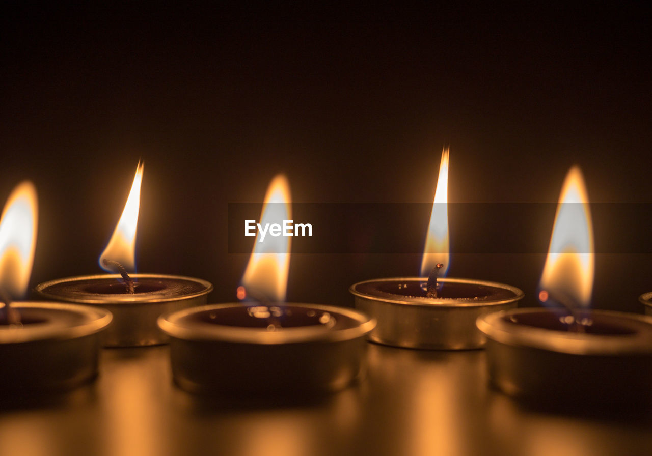 Close-up of illuminated candles on table