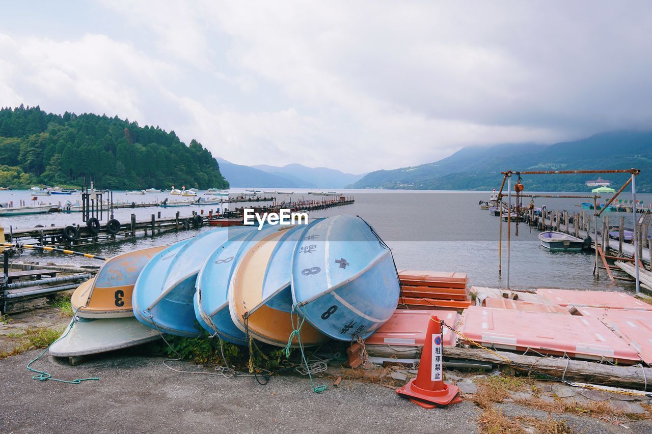 Boats moored on lake against sky