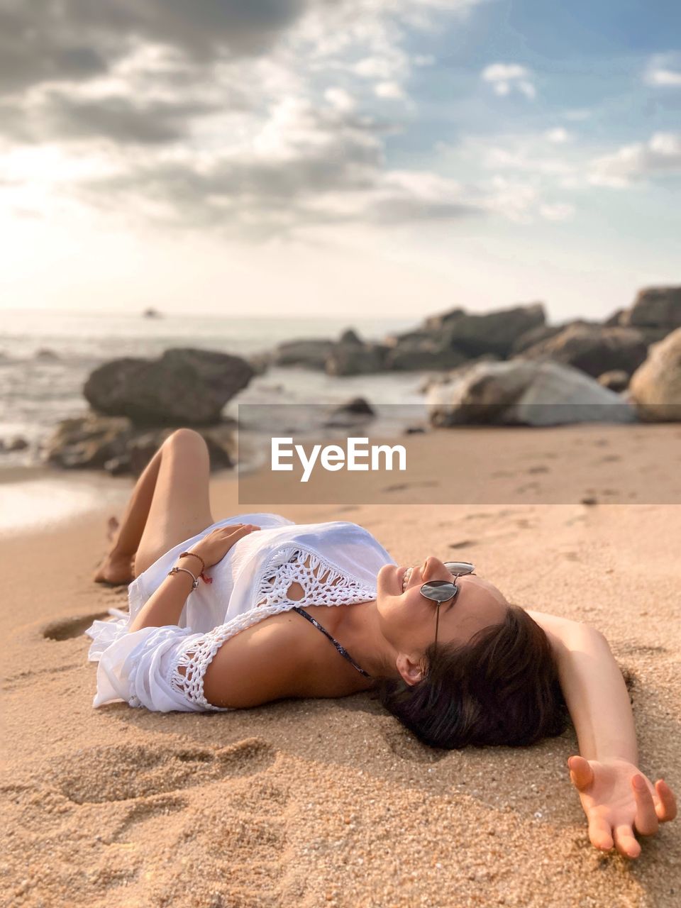 Young girl in white beachwear on the beach.