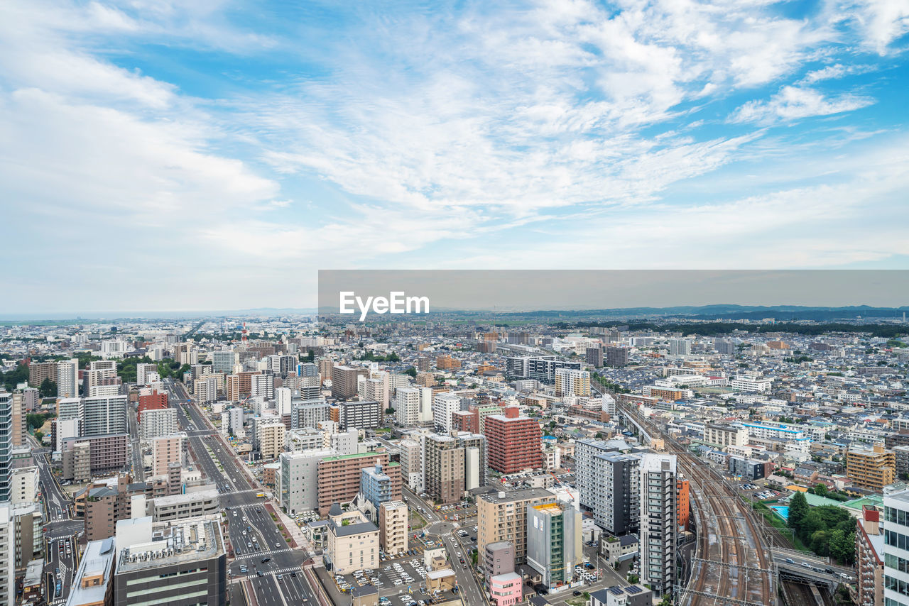 HIGH ANGLE VIEW OF CITYSCAPE AGAINST SKY