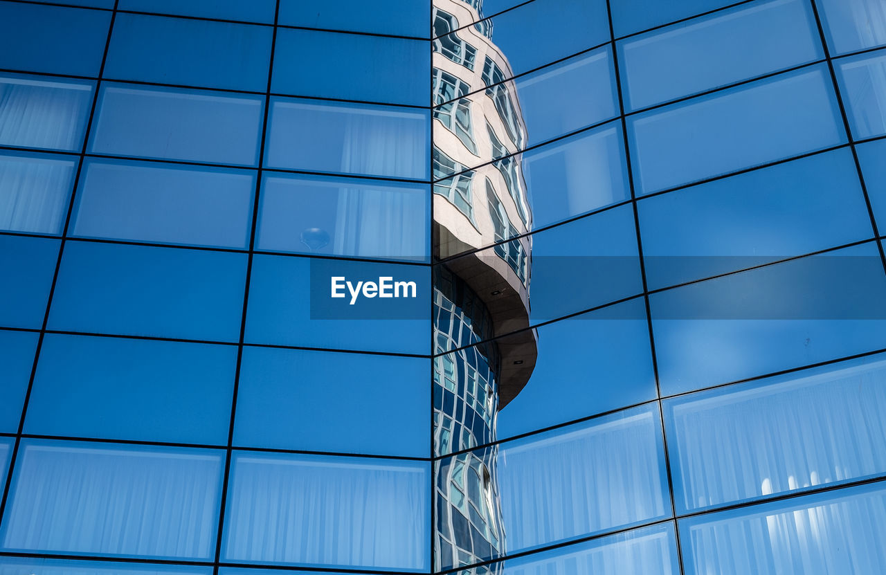 Low angle view of modern building against blue sky