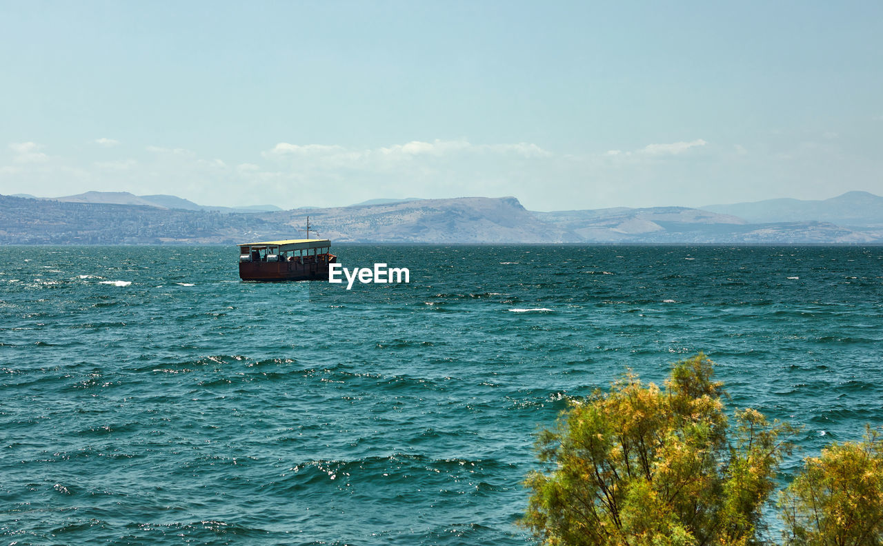 SCENIC VIEW OF BOAT SAILING IN SEA AGAINST SKY