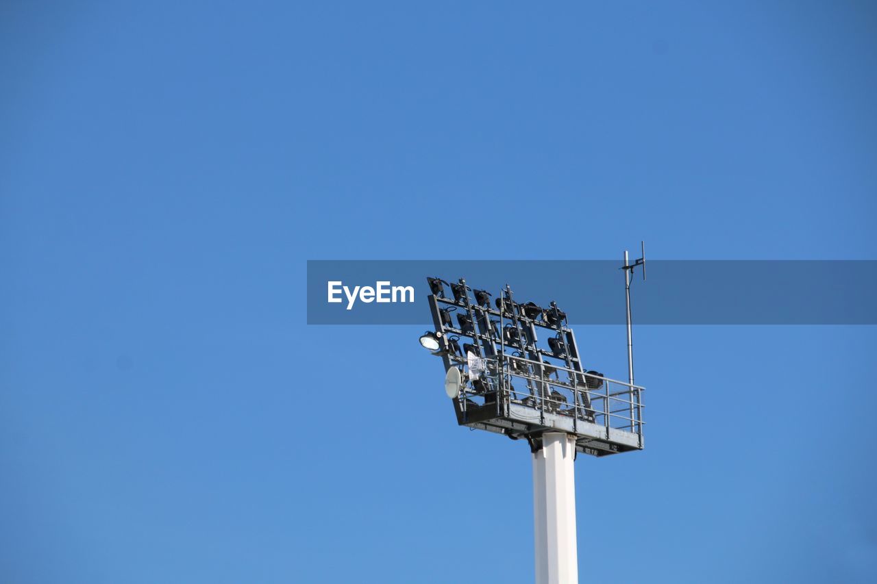 Low angle view of floodlight against clear blue sky