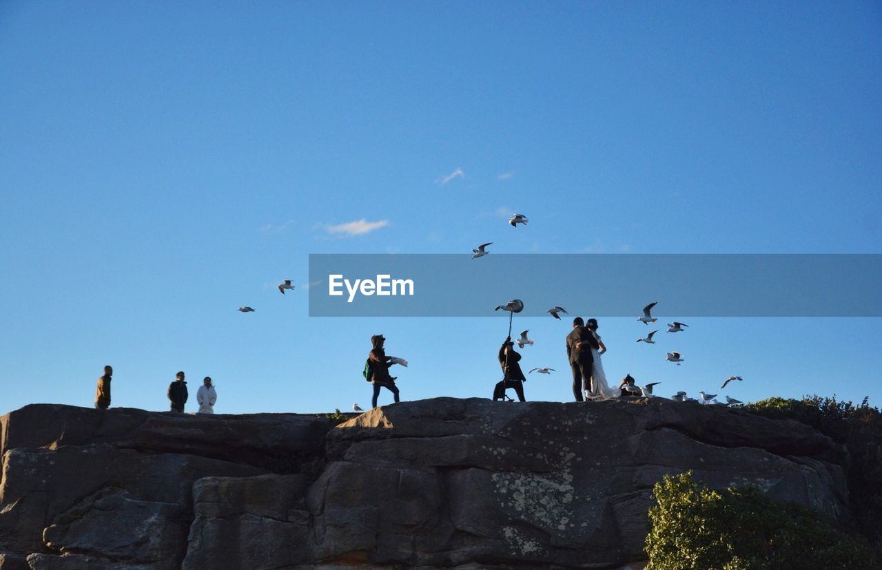 Low angle view of people on hill