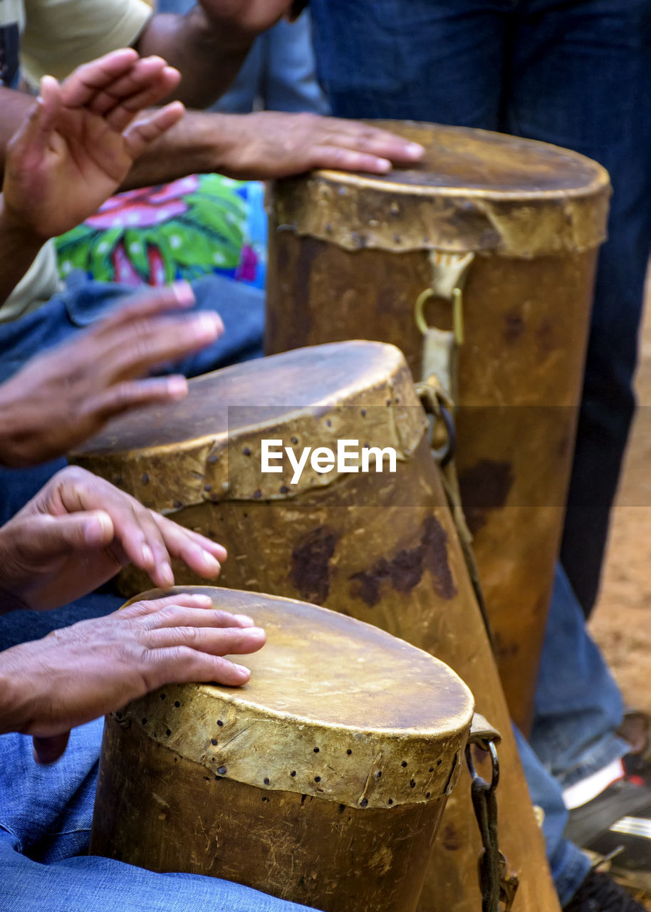 Percussionists group playing a rudimentary atabaque made with leather and wood