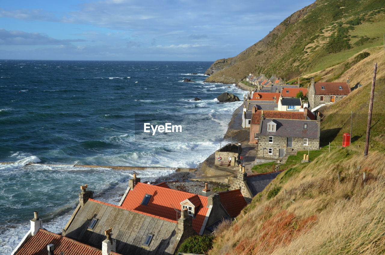 High angle view of buildings by sea against sky