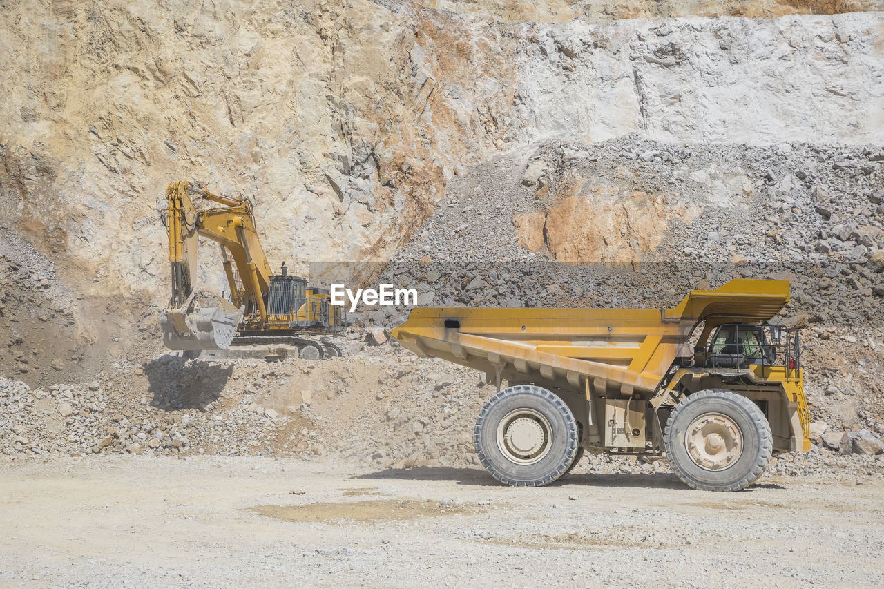 Loader loading mining truck at open pit