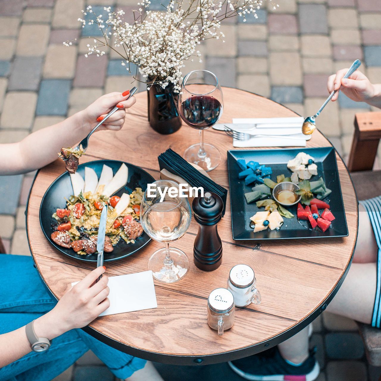 High angle view of hand holding dish and drink on table