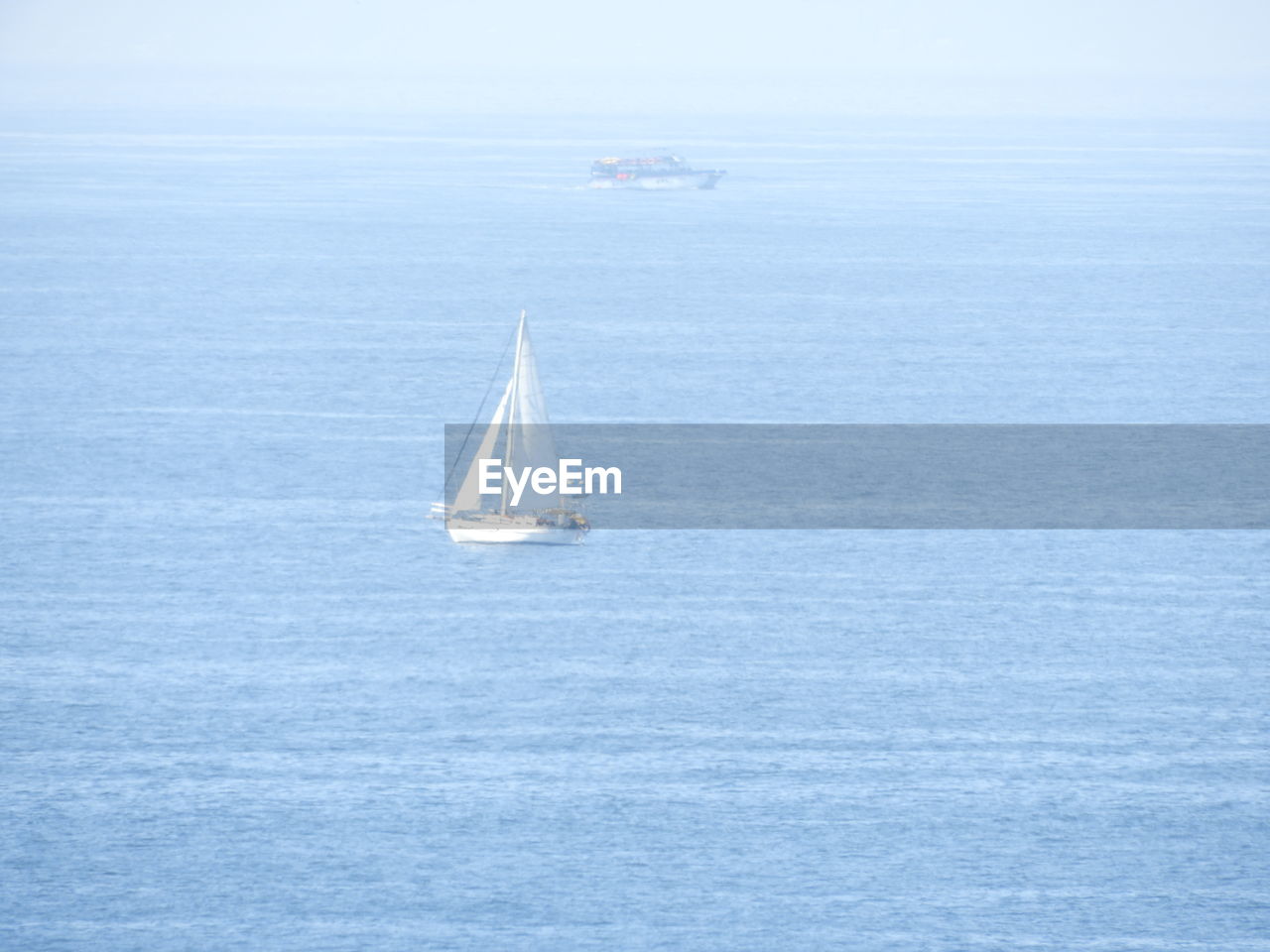 Sailboat sailing in sea against sky