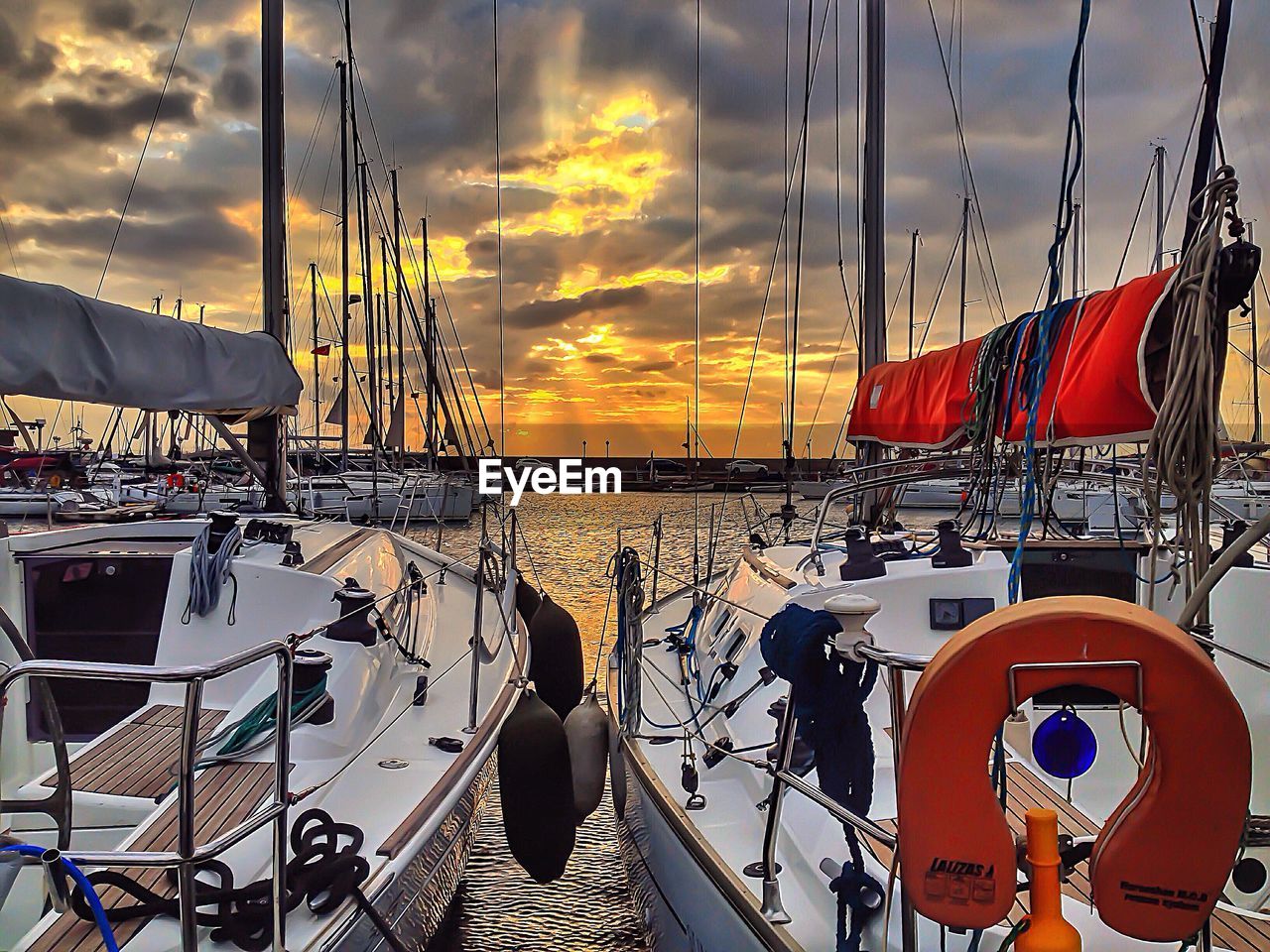 SAILBOATS MOORED AT SUNSET