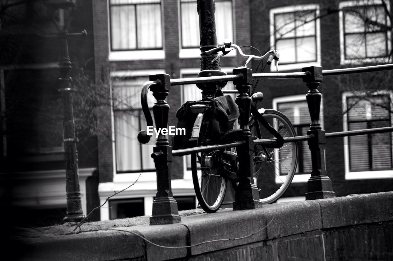 Bicycle parked by railing outdoors