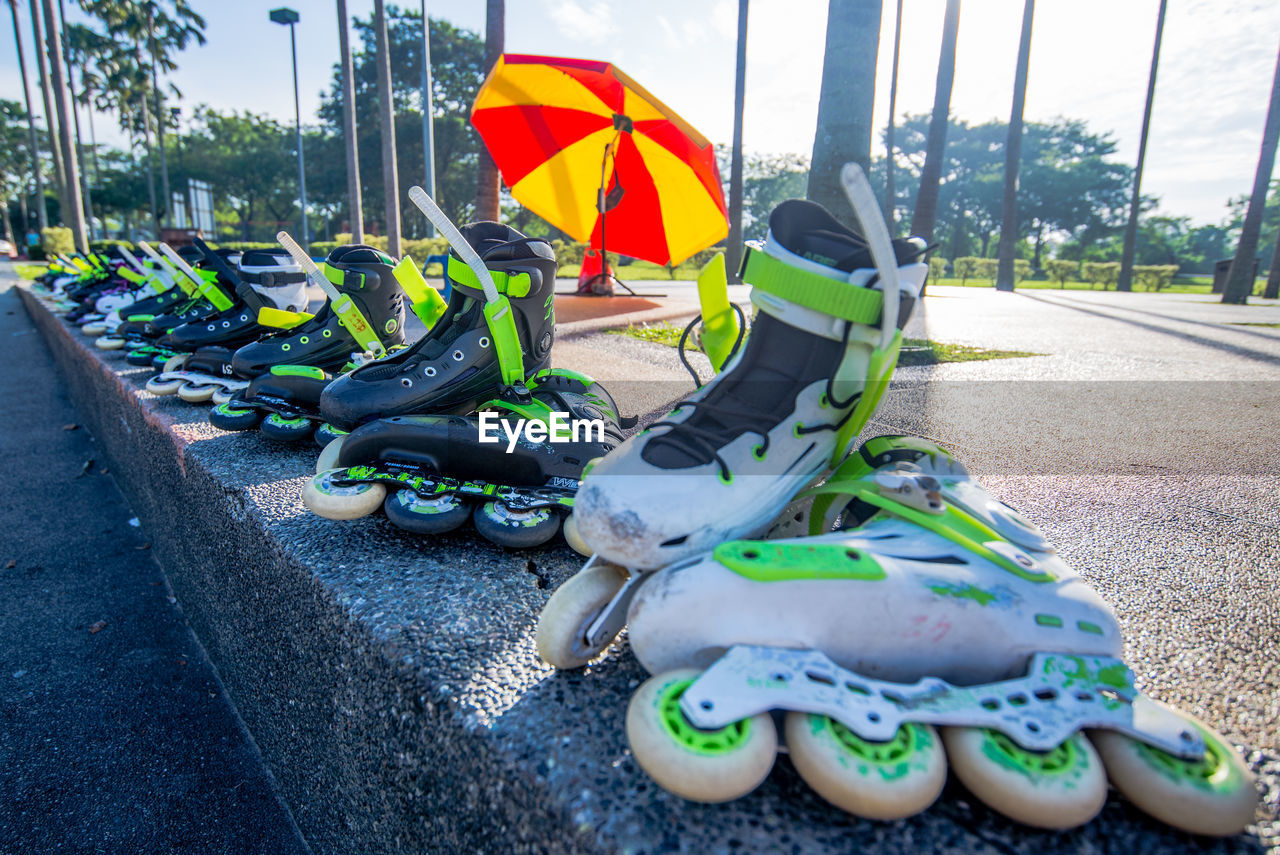 Close-up of rental roller skates on retaining wall on sunny day
