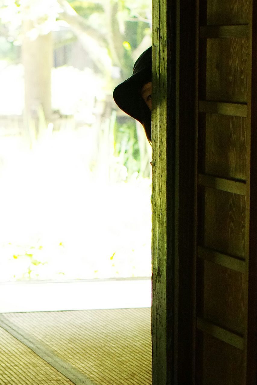 Person peeping through doorway