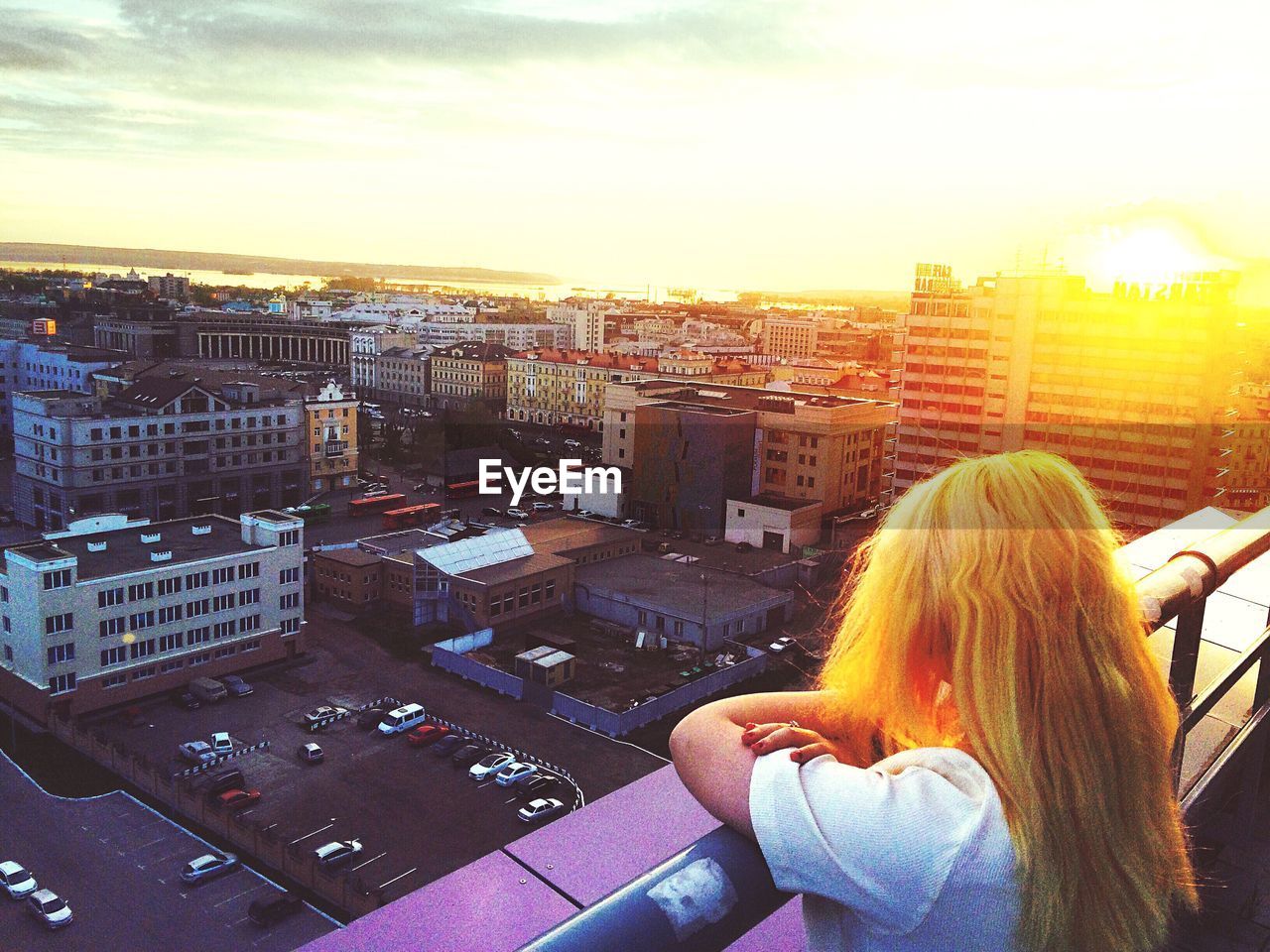 WOMAN STANDING ON CITY STREET DURING SUNSET