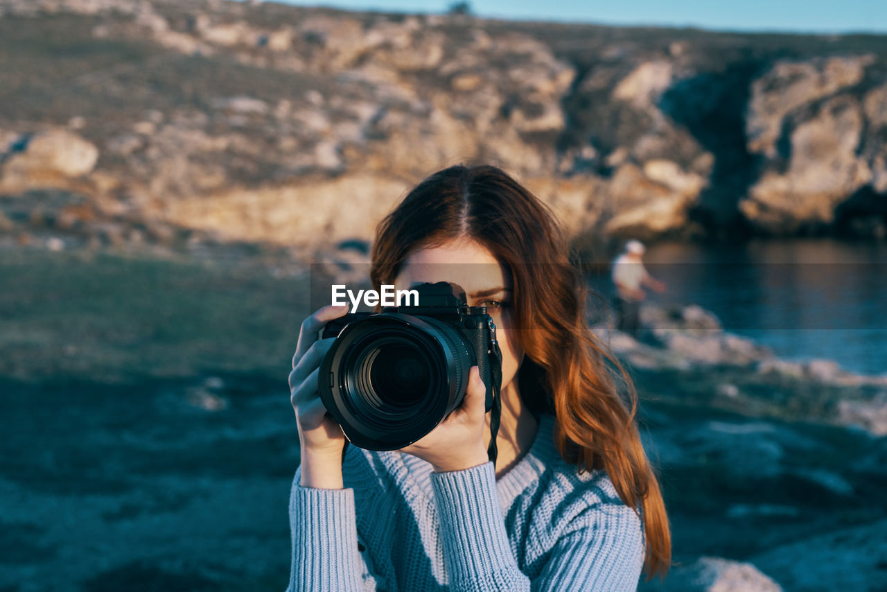 PORTRAIT OF BEAUTIFUL WOMAN PHOTOGRAPHING SEA